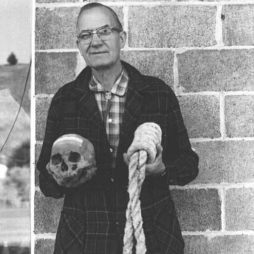 Howard A. Black, Grant County Museum curator, with skull of Berry Way and hangman's rope.